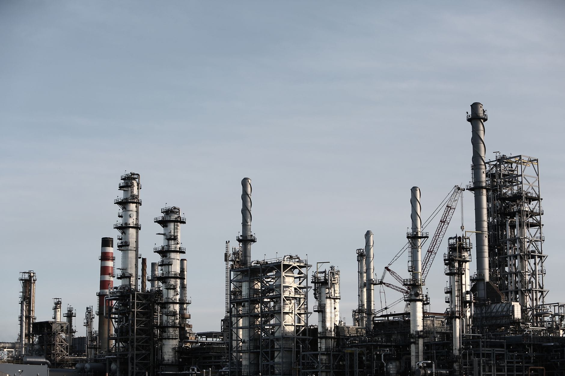 Skyline view of an industrial factory with tall chimneys against a clear sky.